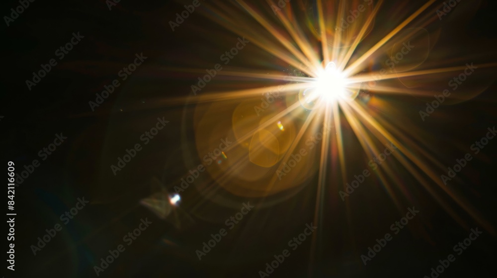 Obraz premium Bright lens flare effect with rays of light and bokeh on dark background for creative design and visual effects