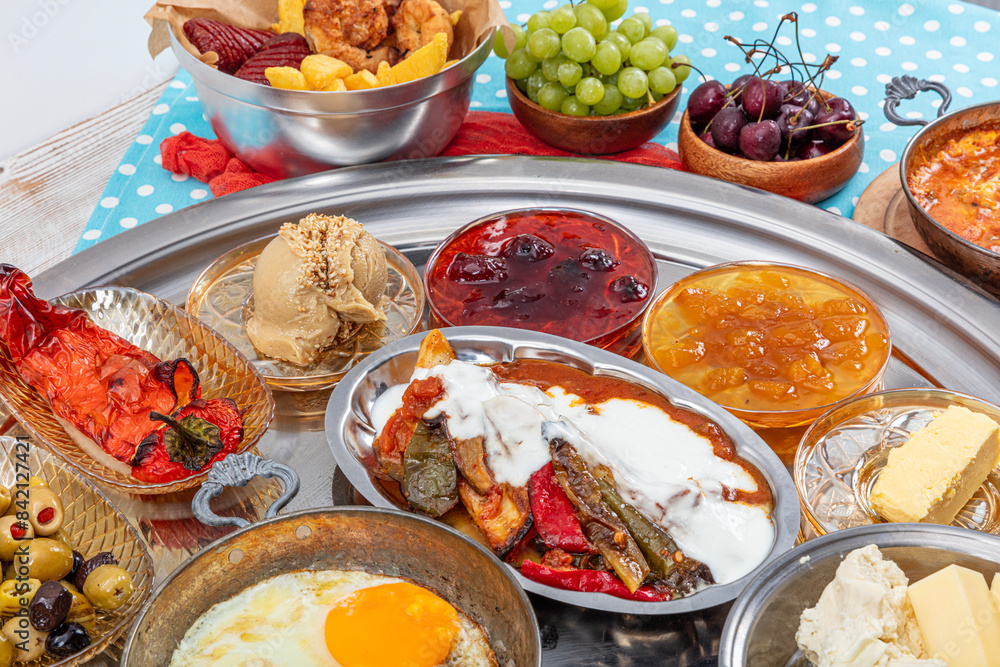 Traditional Turkish Breakfast Table (Serpme Kahvalti). Traditional Turkish village breakfast with fried eggs in a copper pan, menemen, honey clotted cream, cheese varieties on a wooden table. Traditional Turkish Breakfast Table (Serpme Kahvalti). Traditional Turkish village breakfast with fried eggs in a copper pan, menemen, honey clotted cream, cheese varieties on a wooden table.