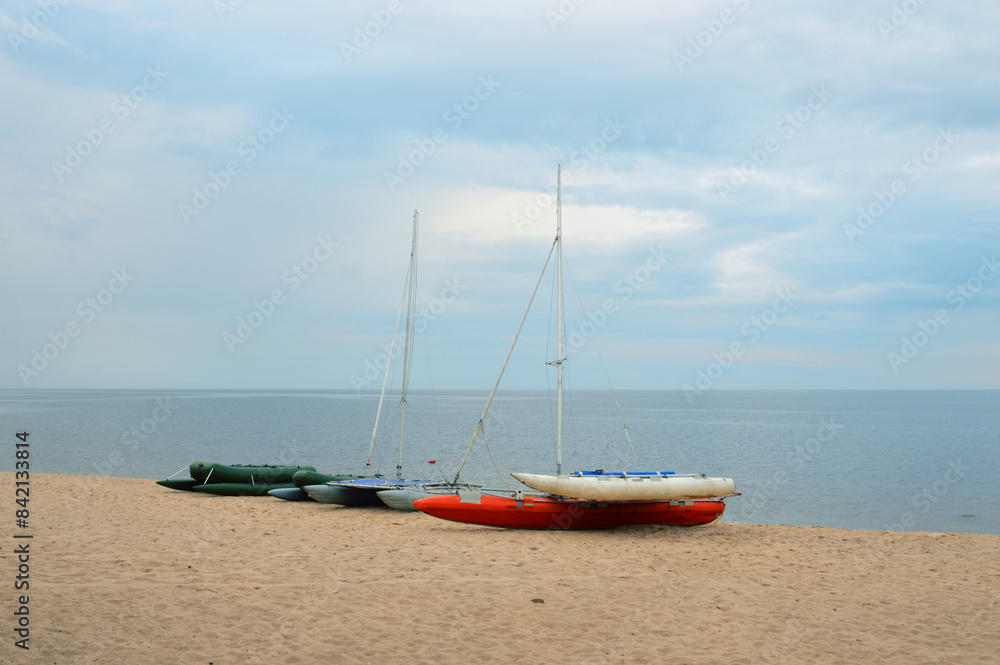Fototapeta premium Catamarans with masts on lake shore.