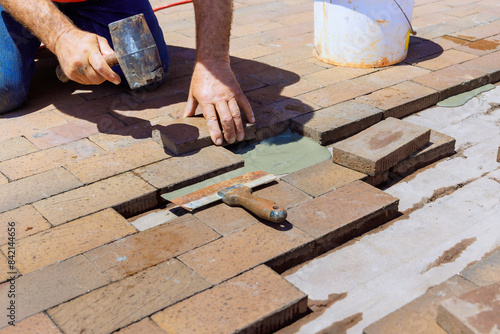 Wallpaper Mural An employee is engaged in repairing footpath by replacing damaged bricks during reconstruction Torontodigital.ca
