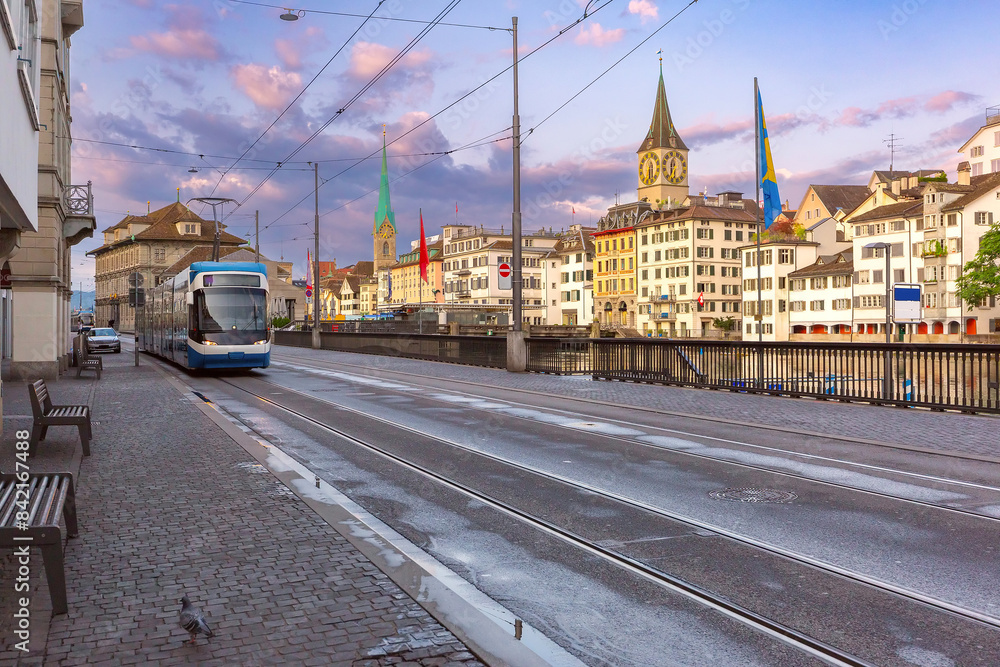 Fototapeta premium Zurich cityscape with tram on Munsterbrucke Bridge with Fraumunster and St Peters Church, Zurich, Switzerland
