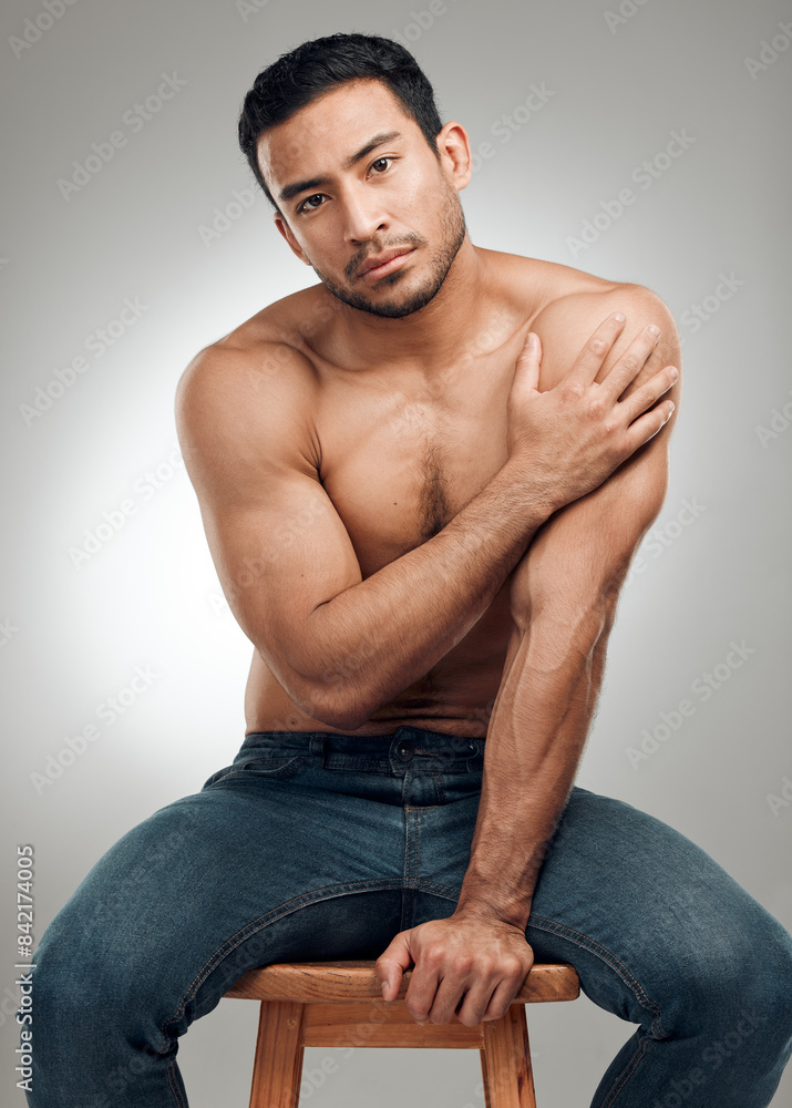Man, chair and shirtless in studio portrait, wellness and strong abs muscle on gray background. Male person, denim jeans and topless for fitness, bodybuilder and proud of body or workout results Man, chair and shirtless in studio portrait, wellness and strong abs muscle on gray background. Male person, denim jeans and topless for fitness, bodybuilder and proud of body or workout results
