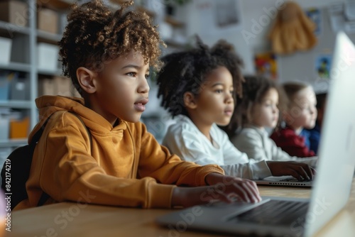 Multiethnic group of children using computers in a classroom.