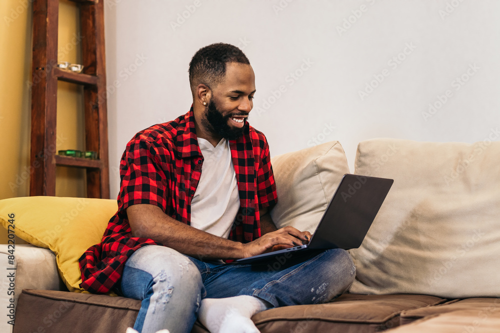 Black man teleworking with laptop from home Black man teleworking with laptop from home