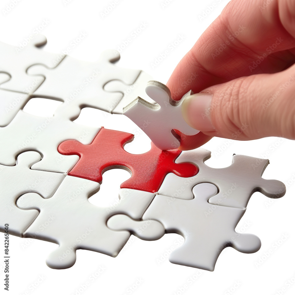 Fototapeta premium A hand placing the final piece of a puzzle with a red center. Concept of problem-solving, completion, and teamwork.