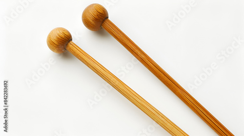 A pair of wooden knitting needles on a white background