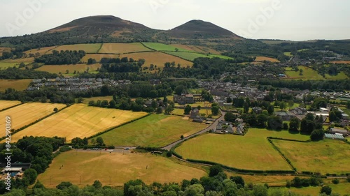 Aerial pullback shot of small Scottish countryside town of Melrose. Lush fields, rolling hills of Eildon and River Tweed below in the Scottish borders, United Kingdom photo