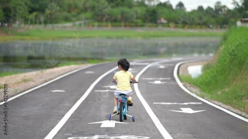 Wallpaper Mural A young girl riding a bicycle down a road with a white line on the side. The road is empty and the girl is the only person on it Torontodigital.ca