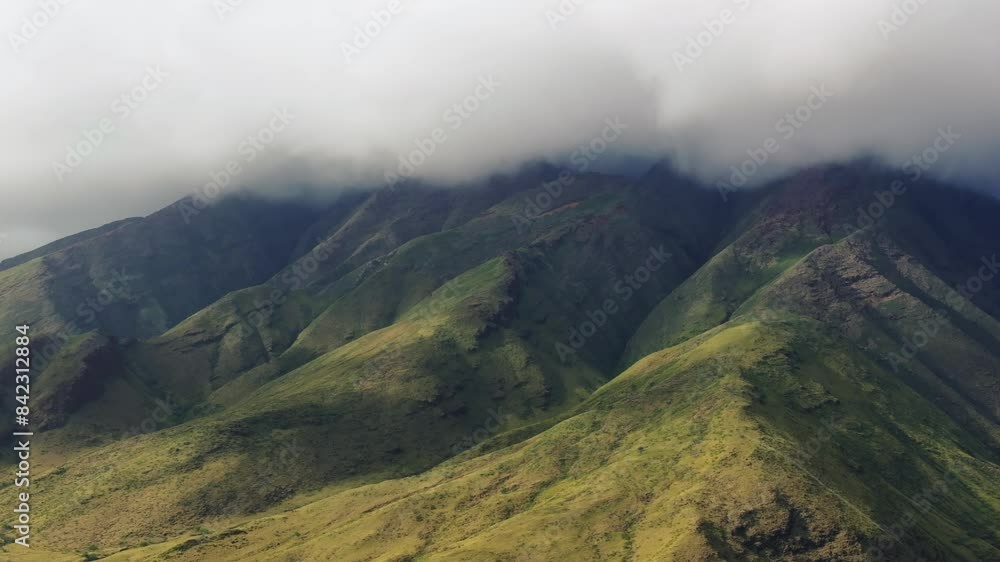 Lush green mountains of Maui covered in clouds creating a serene and majestic landscape Lush green mountains of Maui covered in clouds creating a serene and majestic landscape
