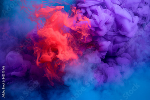 Intense purple and red smoke swirling against a vivid blue fog  creating a contrasting and dramatic abstract background.