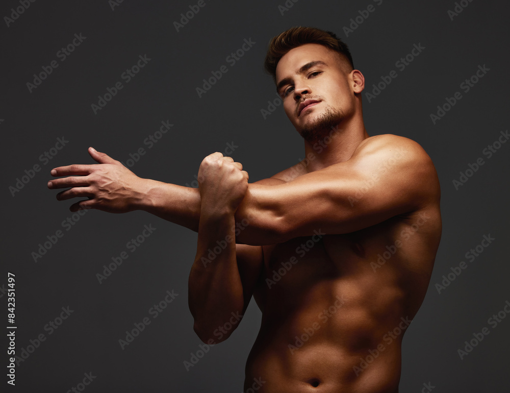 Bodybuilder, man and stretching in studio for exercise, training and fitness for health. Sportsman, athlete and shirtless for wellness by dark background for transformation, workout and self care Bodybuilder, man and stretching in studio for exercise, training and fitness for health. Sportsman, athlete and shirtless for wellness by dark background for transformation, workout and self care