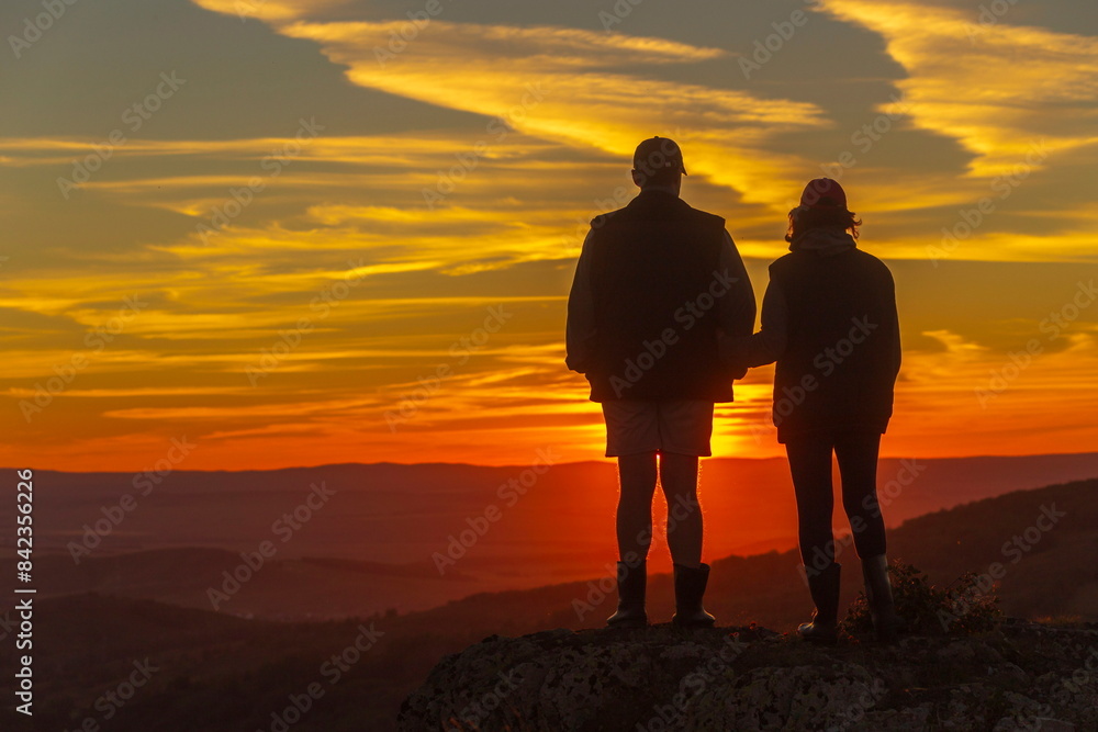 Φωτογραφία two silhouettes of two tourists in love against the background of an evening sun