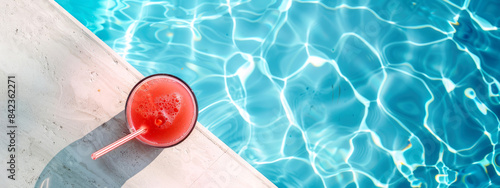 Top view of beautiful summer vacation background with cold watermelon juice by the clear blue swimming pool water. Summer concept banner with copy space