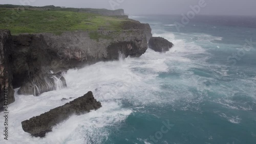 Aerial Slow Mo Churning Waves On Rocky Cliffs Coastline - Hinnamnor photo