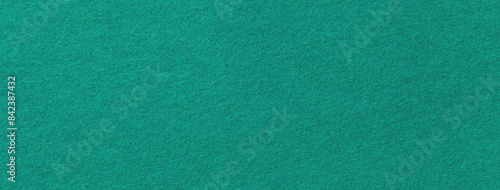 Texture of dark green color background from felt textile material, macro. Vintage cyan fabric cloth