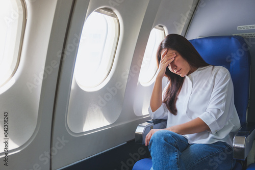 Foto Portrait image of a woman get airsick and headache while traveling on airplane
