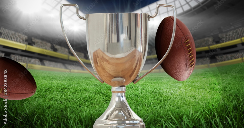 Fototapeta premium Image of silver cup and rugby balls in sports stadium