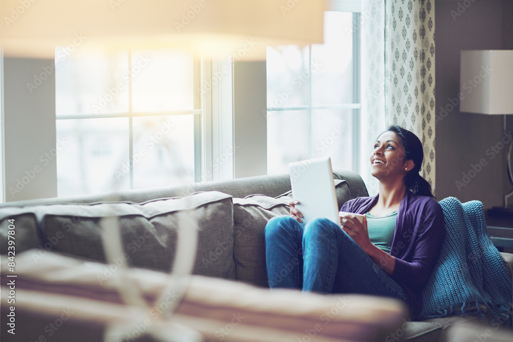 Thinking, woman and tablet on sofa in home for online conversation, communication and weekend on internet. Happy, female person and technology in living room for entertainment and social media Thinking, woman and tablet on sofa in home for online conversation, communication and weekend on internet. Happy, female person and technology in living room for entertainment and social media