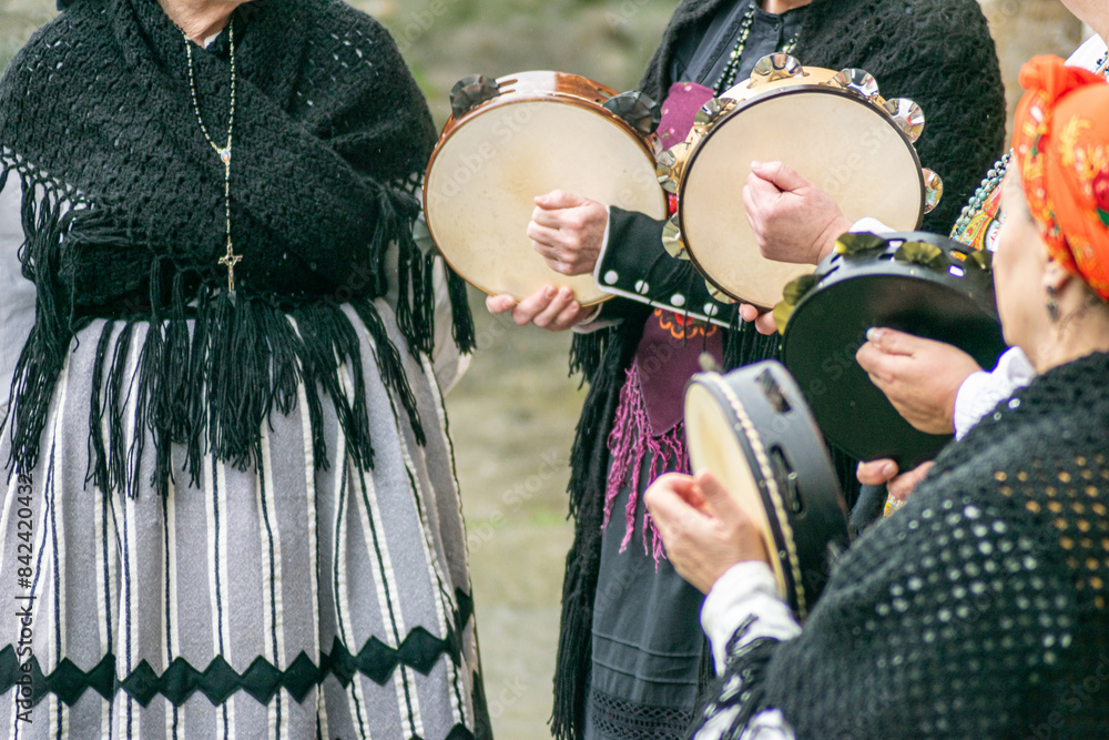 Φωτογραφία women dressed in traditional Galician costume playing tambourines at a popular f