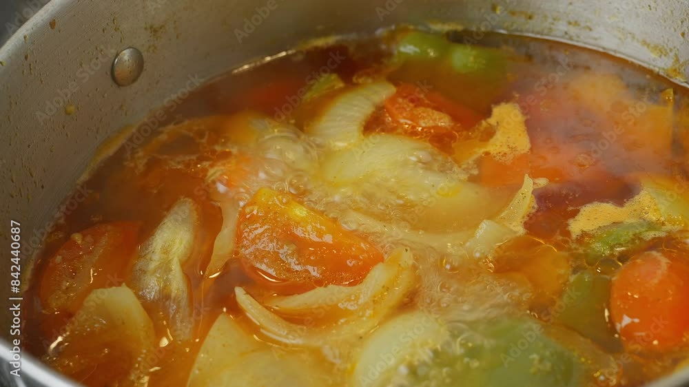 Cooking Video. Close up of food cooking simmering in a pan full of curry sauce, soup or stew placing ingredients herbs spices pan ready for cooking. Happy household chores healthy eating concept. Cooking Video. Close up of food cooking simmering in a pan full of curry sauce, soup or stew placing ingredients herbs spices pan ready for cooking. Happy household chores healthy eating concept.
