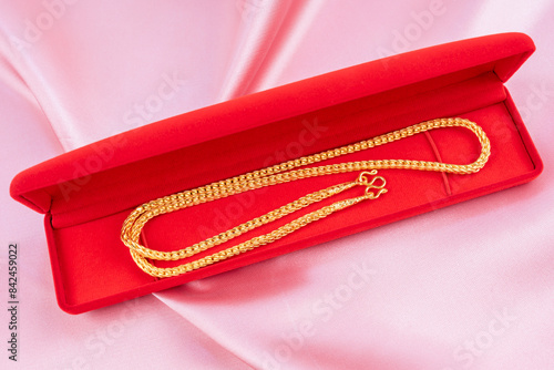 Wallpaper Mural Gold Necklace in red velvet box container on pink fabric background. Torontodigital.ca