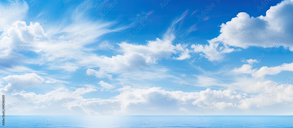 Obraz premium Tranquil scene of a clear blue sky dotted with fluffy clouds on a sunny day, providing a peaceful natural backdrop with room for design in a copy space image.
