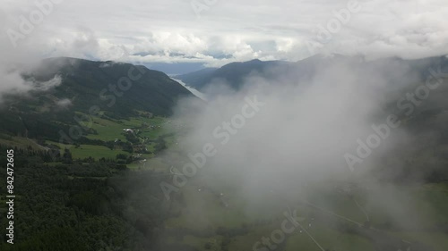 Aerial Drone Shot Flying through a Cloud Revealing Vikøyri in Vik i Sogn, Norway. Forwards Drone shot on a cloudy day photo