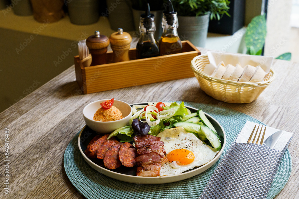 Breakfast with bacon, fried eggs, sausage and salad Breakfast with bacon, fried eggs, sausage and salad