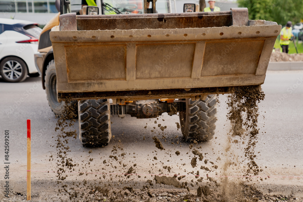 Wheel loader dropping out gravel from bucket on construction job site Wheel loader dropping out gravel from bucket on construction job site