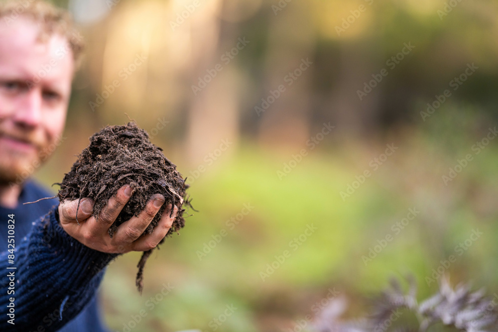 turning a compost pile in a community garden. compost full of microorganisms. sustainable regenerative agriculture turning a compost pile in a community garden. compost full of microorganisms. sustainable regenerative agriculture