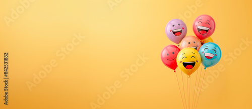 ballons à l'hélium avec des émoticônes dessus sur un fond jaune, format panoramique - espace vide pour texte