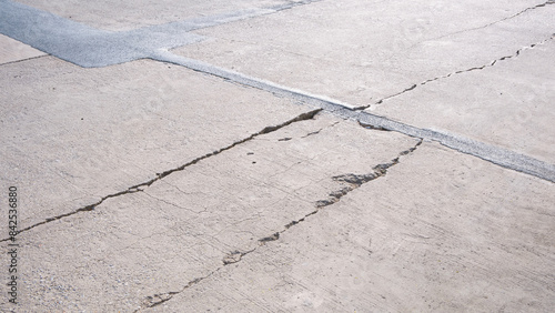Long broken crack lines texture on surface of the old damaged concrete road floor background photo