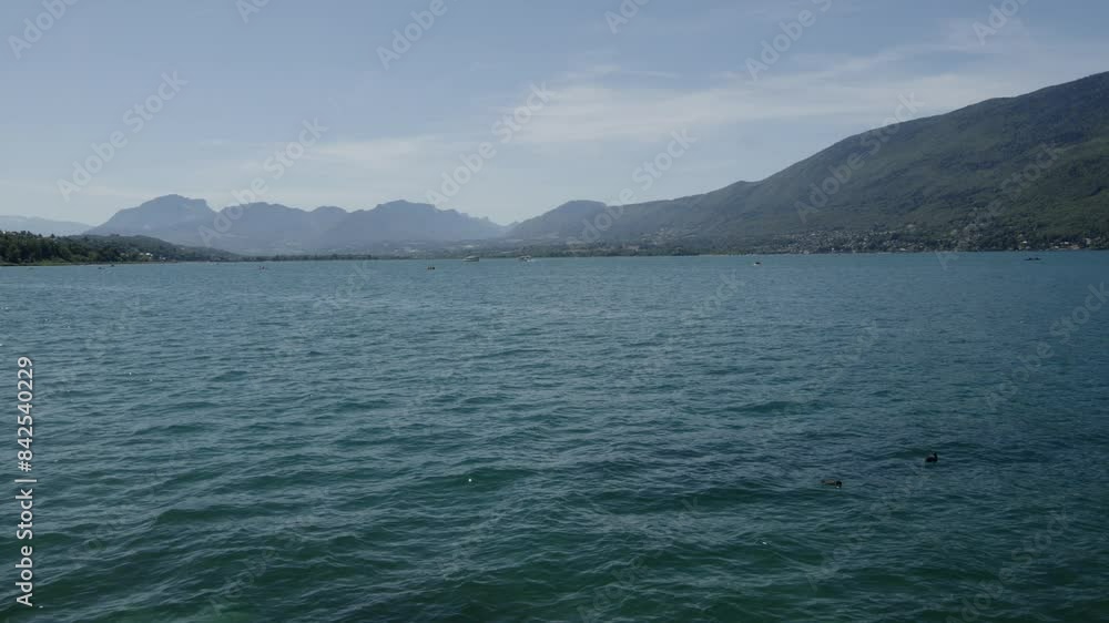 Slow motion navigation in blue lake below alpine mountain background daylight Slow motion navigation in blue lake below alpine mountain background daylight