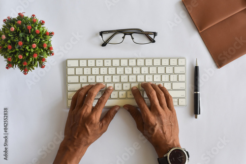 Asian man hand typing on keyboard flat lay or top down view from above