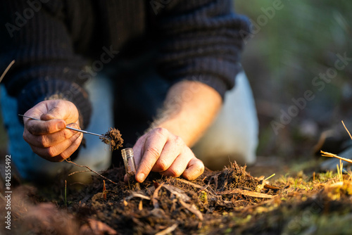 Fotografie farmer collecting soil samples in a test tube in a field