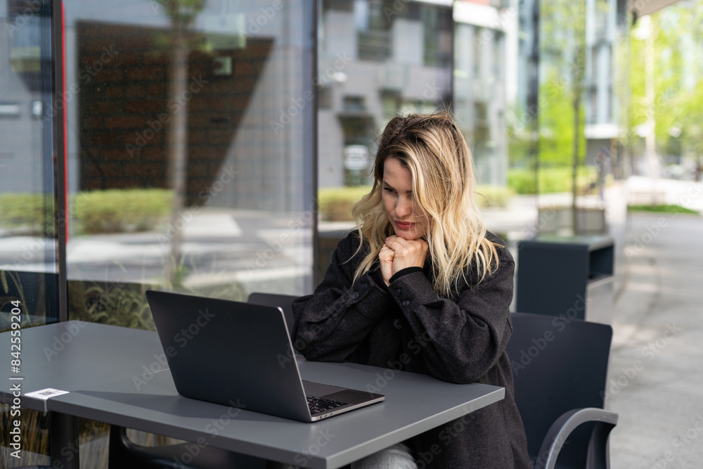 Tired young business woman in black suit with headphones is sitting with eyes closed in front of laptop Tired young business woman in black suit with headphones is sitting with eyes closed in front of laptop