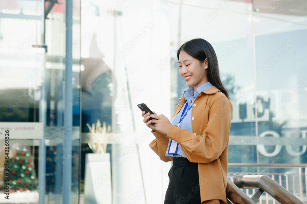Young Asian business woman leader entrepreneur, professional manager holding digital tablet computer on the street in big city on business center background.. Young Asian business woman leader entrepreneur, professional manager holding digital tablet computer on the street in big city on business center background..