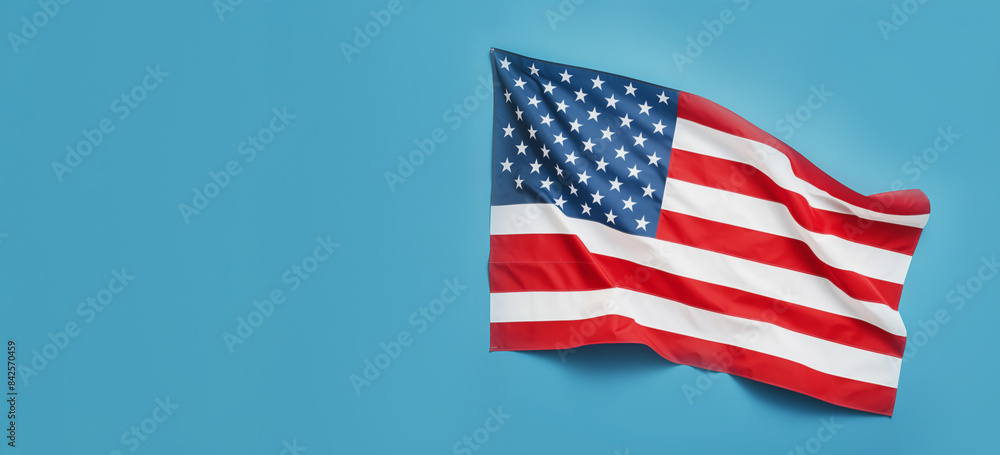 American flag waving on blue background, horizontal banner with copy space, US flag is positioned on right side of frame, related to patriotism, national holidays, Independence Day, political events American flag waving on blue background, horizontal banner with copy space, US flag is positioned on right side of frame, related to patriotism, national holidays, Independence Day, political events