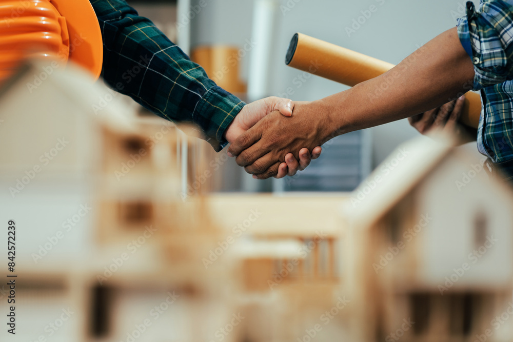 Obraz premium Engineering people and contractor wearing safety helmet on construction site holding blueprint in his hand.