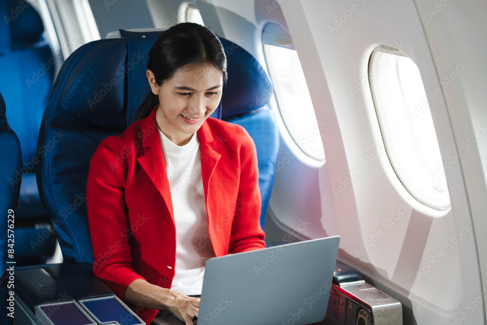 Traveling and technology. young business woman working on smartphone and Laptop computer, Tablet while sitting in airplane. Traveling and technology. young business woman working on smartphone and Laptop computer, Tablet while sitting in airplane.