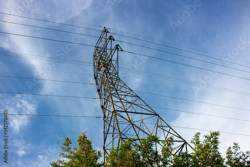 high voltage pylon against blue sky,  Sute tower electric high voltage blue sky tower sutet indonesia, Transmission tower or power line on a sunny day. These are scattered throughout in indonesia photo