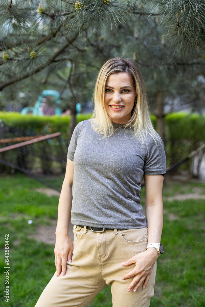 Fototapeta premium Beautiful young urban woman walking outside in park of the office building. High quality photo