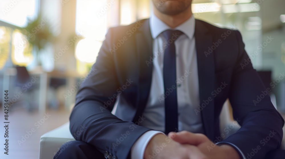 Professional businessman in a suit sitting confidently at a desk. Corporate leadership concept. Professional businessman in a suit sitting confidently at a desk. Corporate leadership concept.