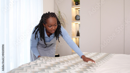 African American maid arranging a hotel room