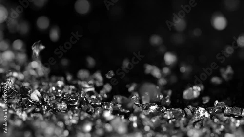 Black сopper slag crystals being poured. Close up. Black sand pouring in slow motion. photo