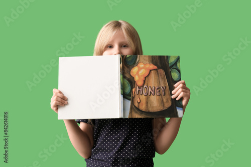 Young girl holding open boo...