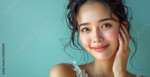Portrait of a Smiling Woman With Wavy Black Hair Against a Teal Background