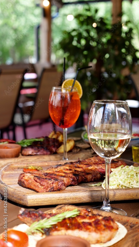 A festive table in a restaurant on a summer terrace with alcoholic drinks and meat and pork food A festive table in a restaurant on a summer terrace with alcoholic drinks and meat and pork food