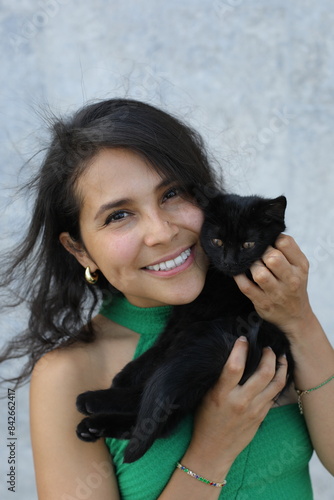 Pretty woman with a very cute black baby cat 