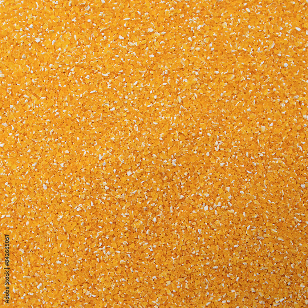 Bright yellow corn grits, closeup. Corn grits texture as background.